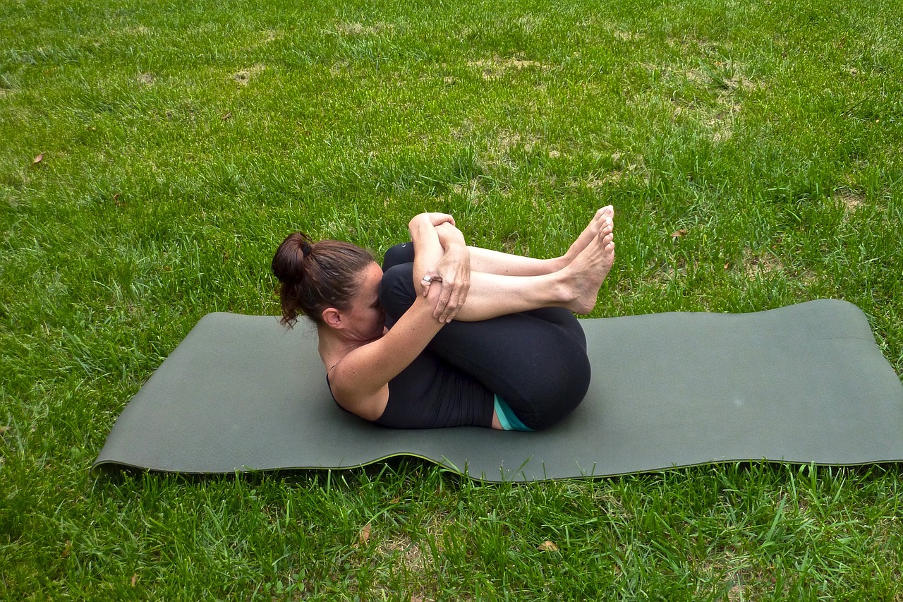 woman doing yoga on a green lawn