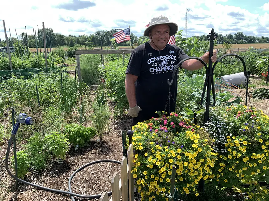 gardener with flowers at community garden