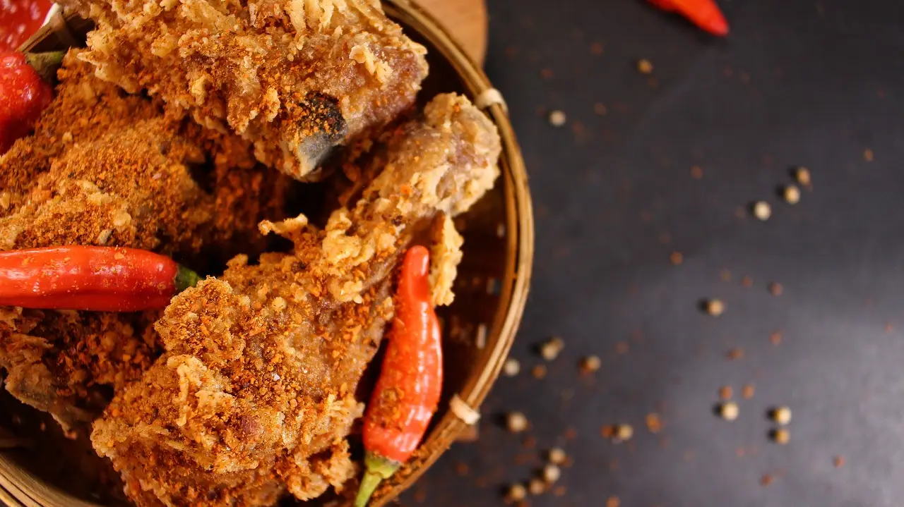 friend chicken drumstick in a bowl with hot peppers