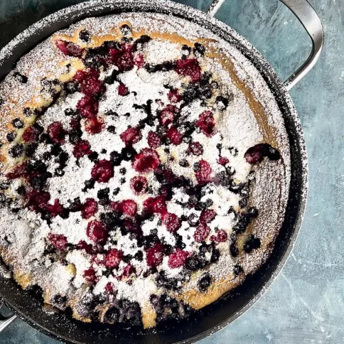 dutch baby with berries and powdered sugar